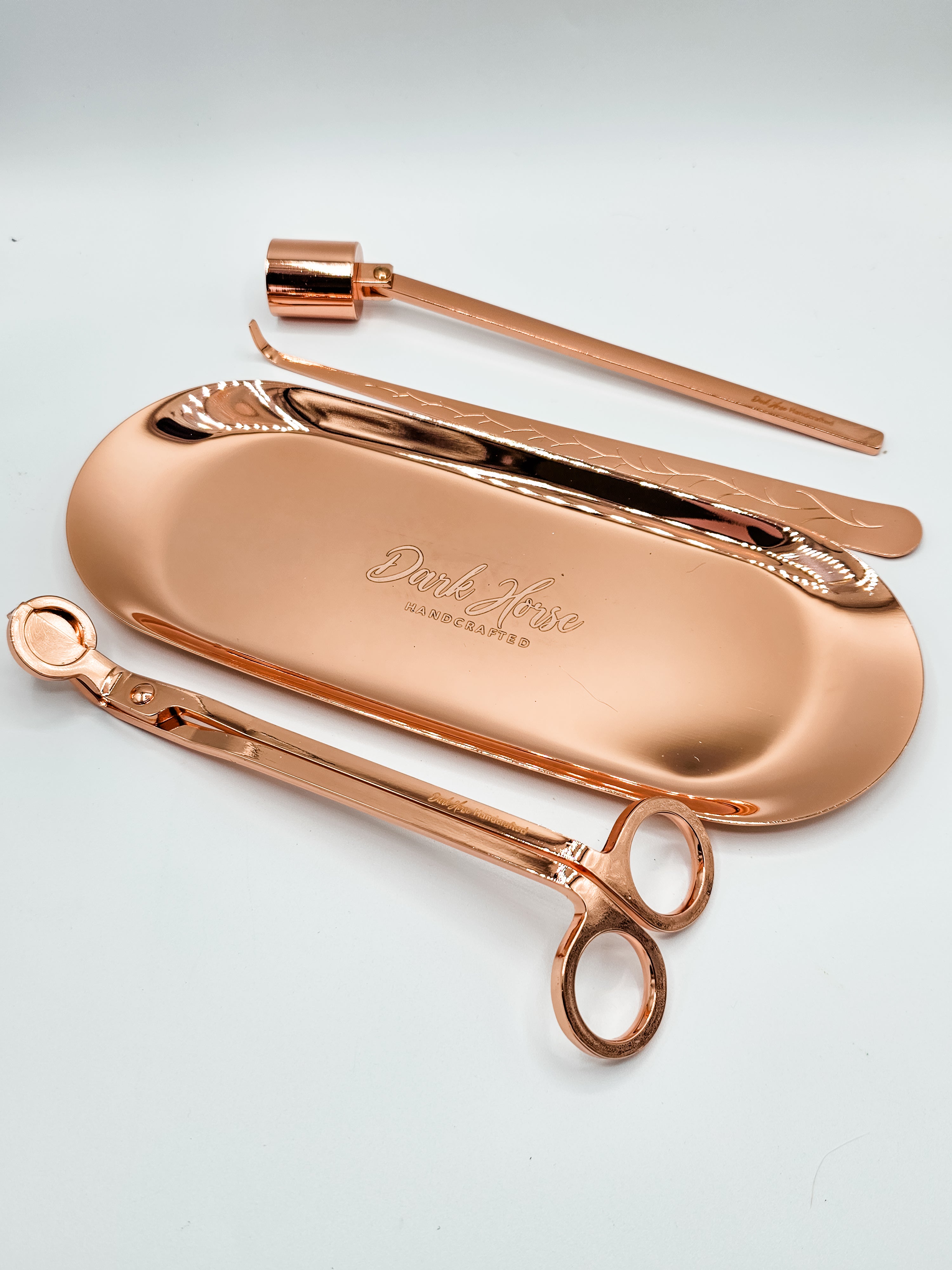 Rose gold candle accessory kit which includes tray, snuffer, wick dipper & wick trimmer.