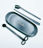 Matte black candle accessory kit which includes tray, snuffer, wick dipper & wick trimmer.